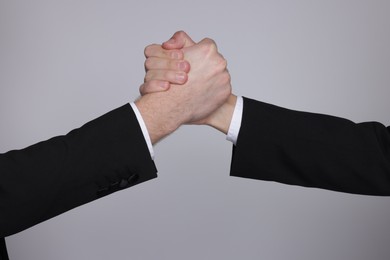 Photo of Businessmen competing on grey background, closeup view