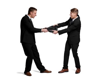 Photo of Competition concept. Businessmen pulling leather briefcase on grey background