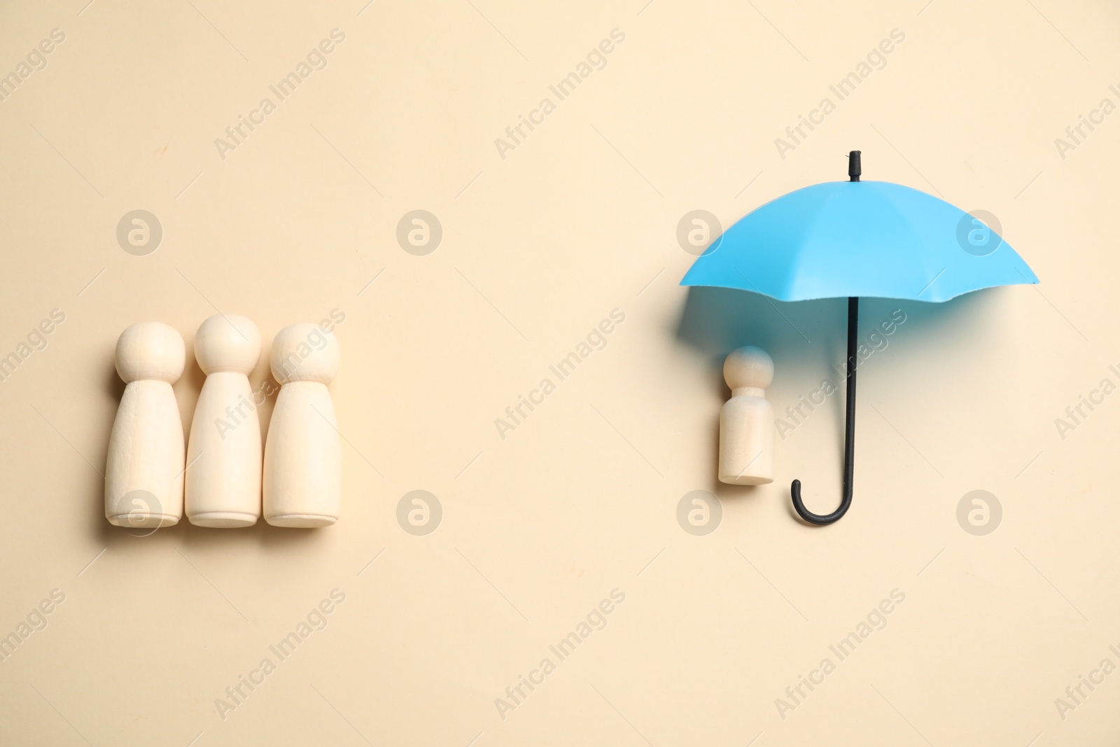 Photo of Human figures under umbrella on beige background, top view. Insurance concept