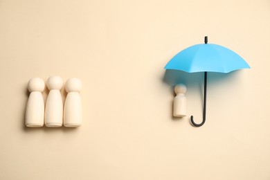 Photo of Human figures under umbrella on beige background, top view. Insurance concept