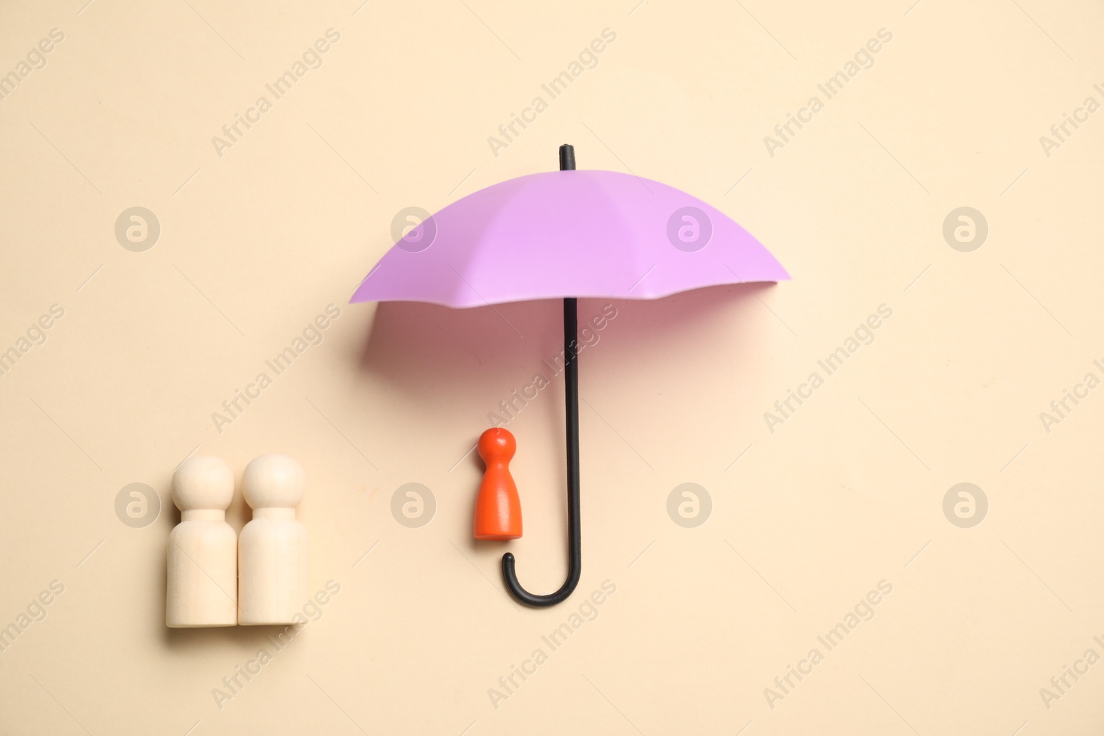 Photo of Human figures under umbrella on beige background, top view. Insurance concept