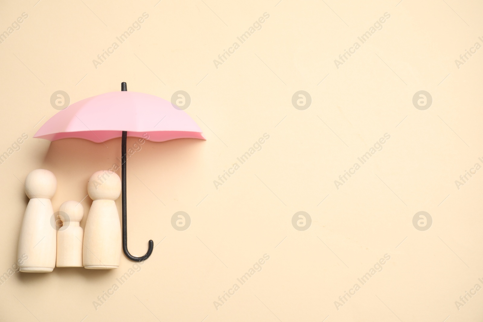 Photo of Human figures under umbrella on beige background, top view with space for text. Insurance concept