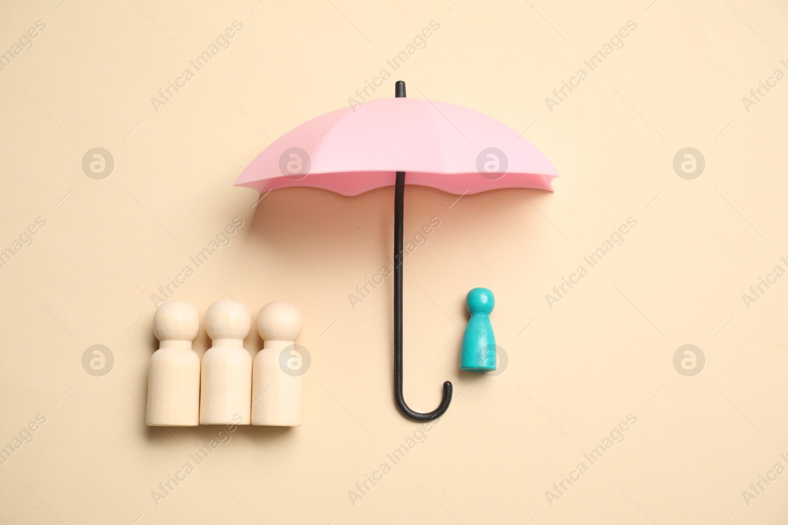 Photo of Human figures under umbrella on beige background, top view. Insurance concept