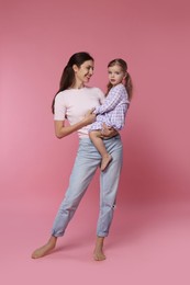 Photo of Happy mother with her cute little daughter on pink background