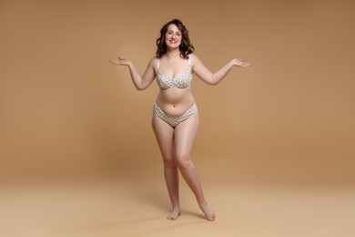 Photo of Beautiful woman in underwear on dark beige background. Cellulite problem