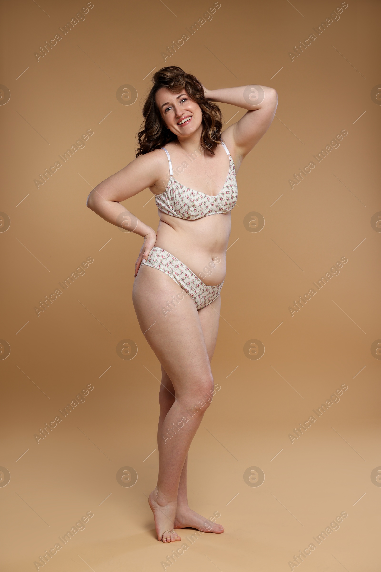 Photo of Beautiful woman in underwear on dark beige background. Cellulite problem