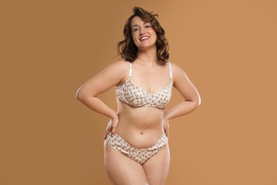 Photo of Beautiful woman in underwear on dark beige background. Cellulite problem