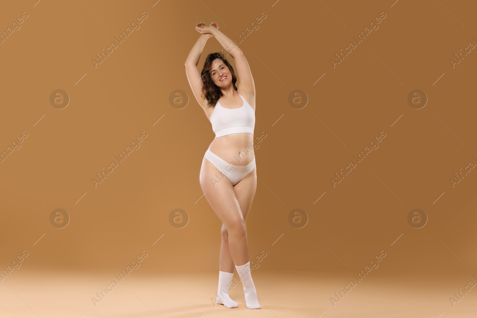 Photo of Beautiful woman in underwear on dark beige background. Cellulite problem