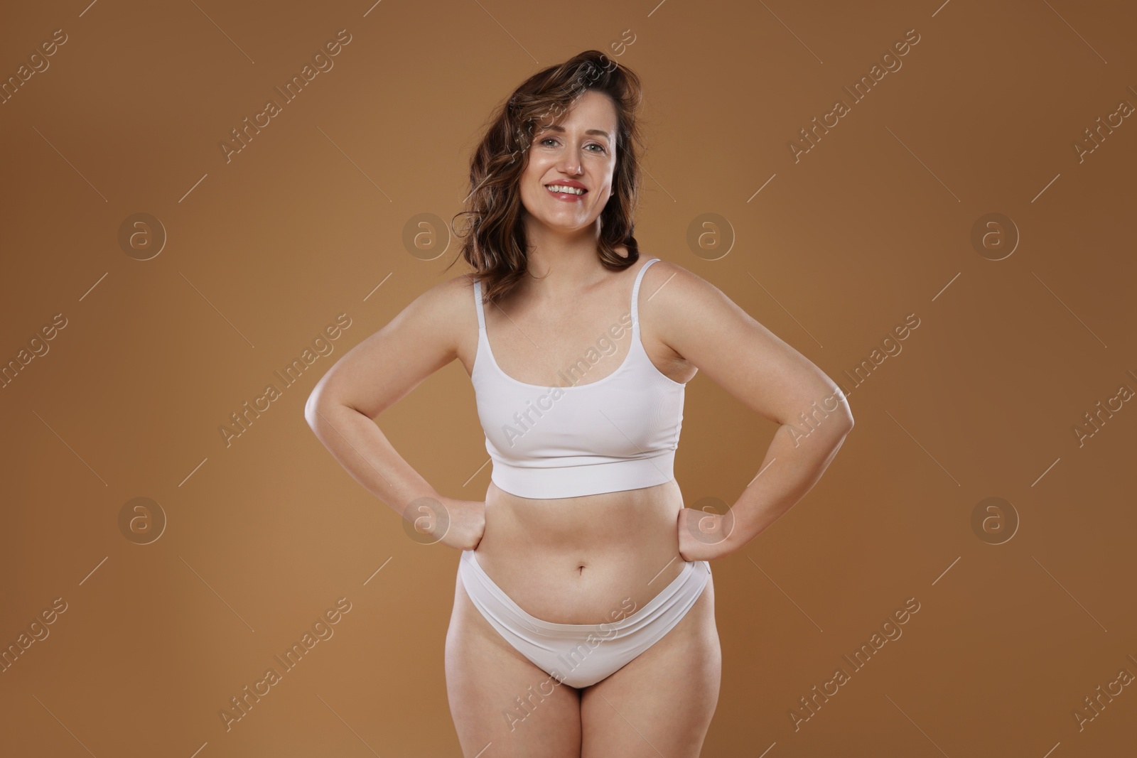 Photo of Beautiful woman in underwear on dark beige background. Cellulite problem