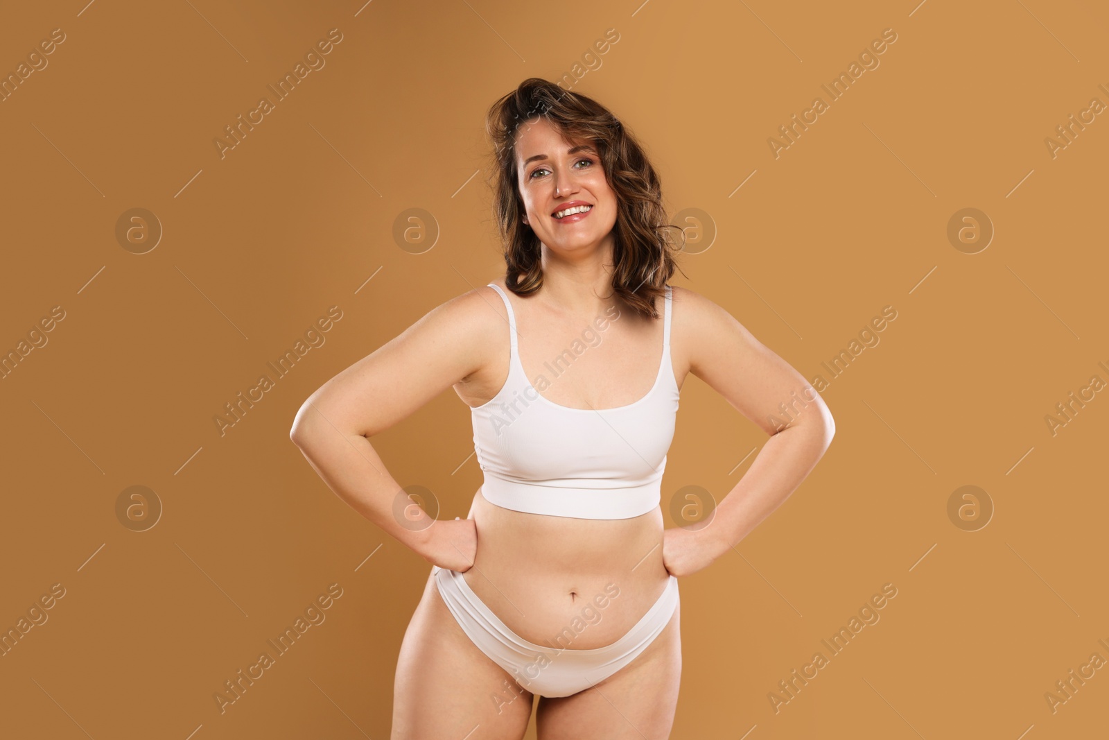 Photo of Beautiful woman in underwear on dark beige background. Cellulite problem