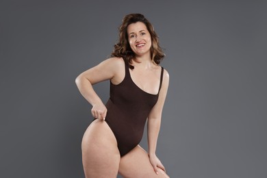 Beautiful woman in bodysuit on dark grey background, space for text. Cellulite problem