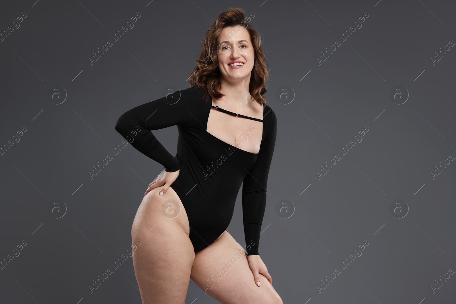 Photo of Beautiful woman in bodysuit on dark grey background, space for text. Cellulite problem