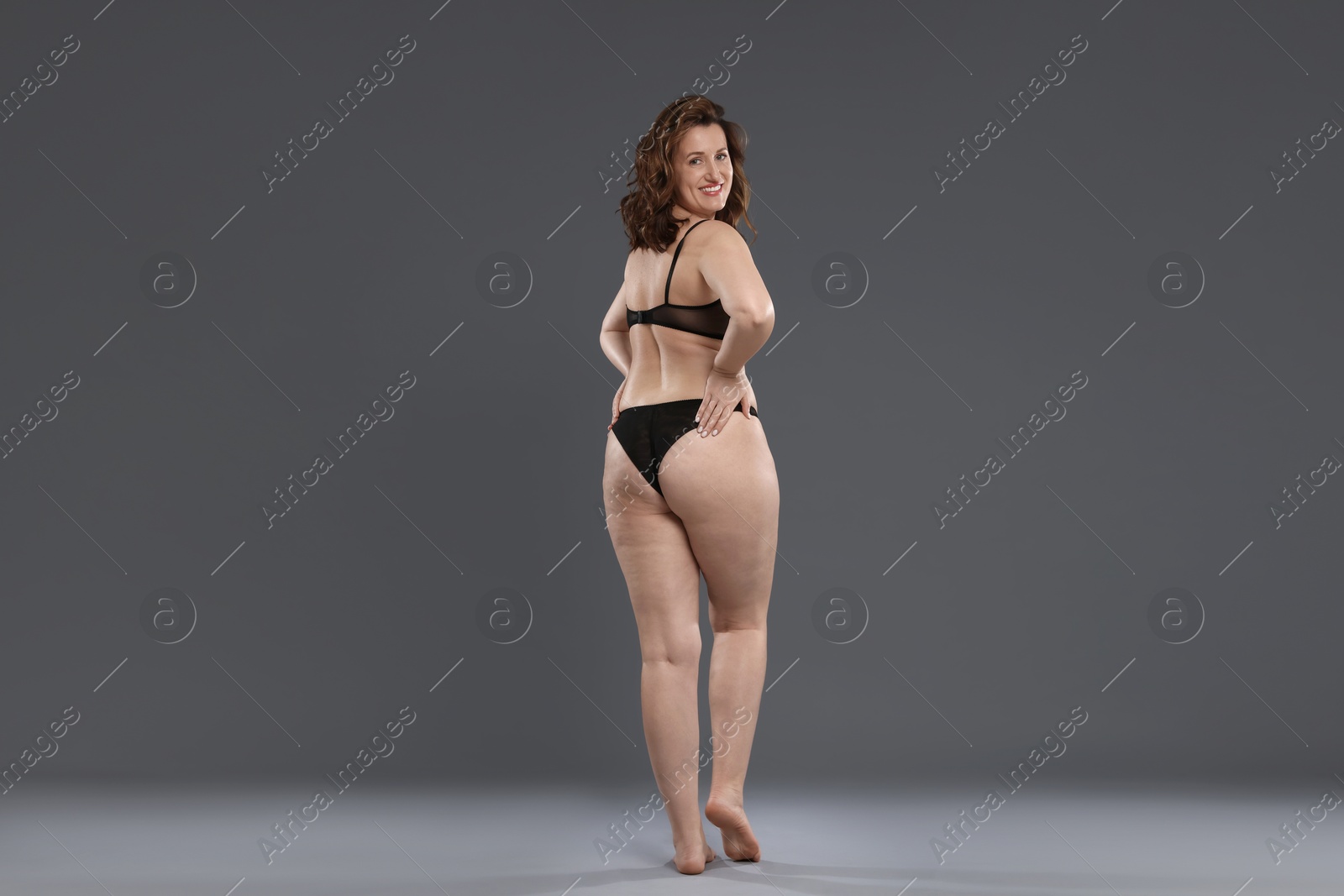 Photo of Beautiful woman in underwear on dark grey background. Cellulite problem