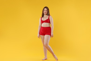 Woman in red underwear on orange background. Cellulite problem