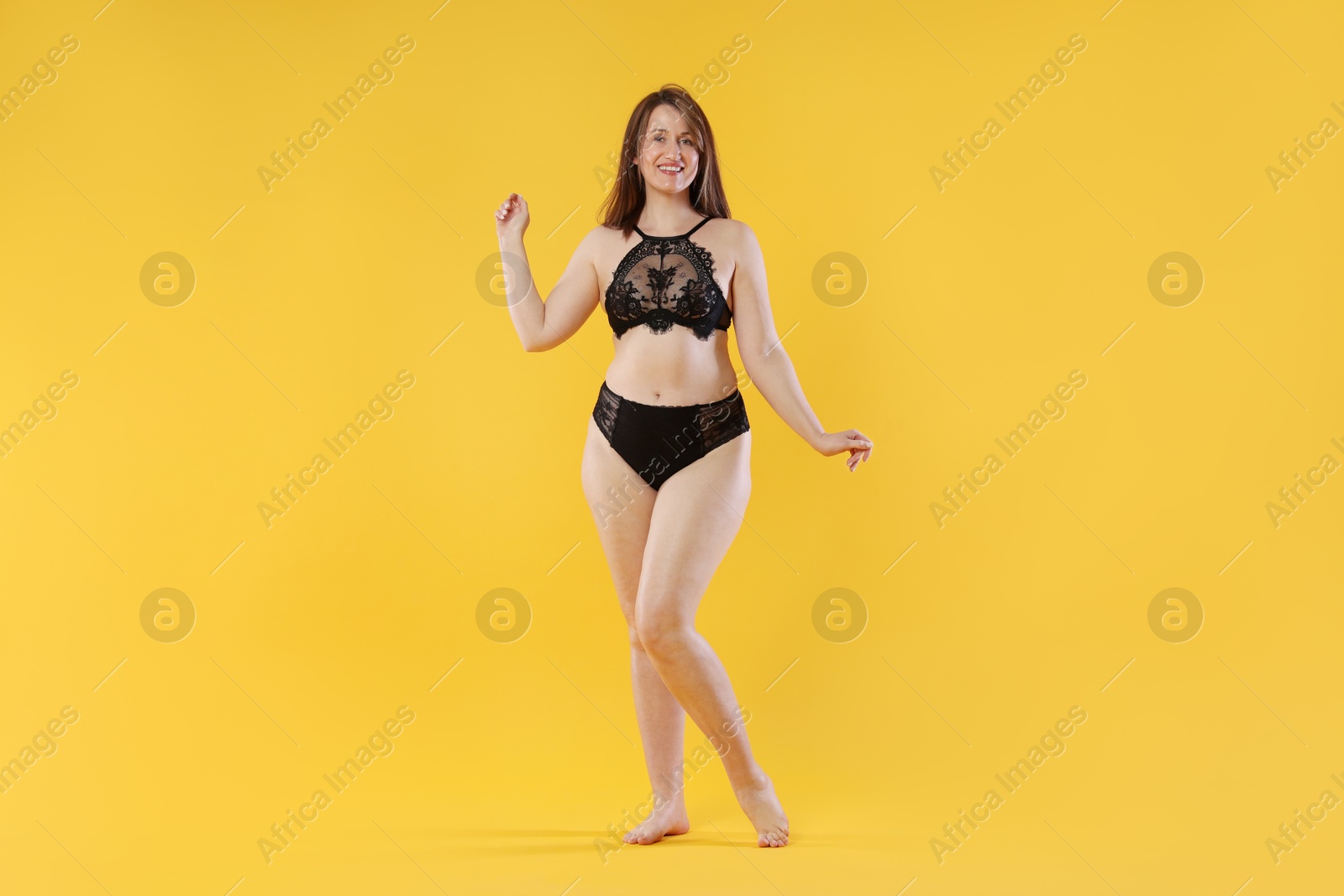 Photo of Woman in underwear on orange background. Cellulite problem