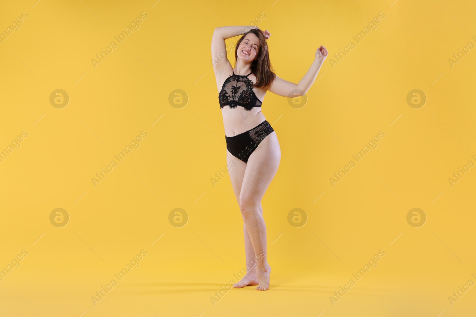 Photo of Woman in underwear on orange background. Cellulite problem