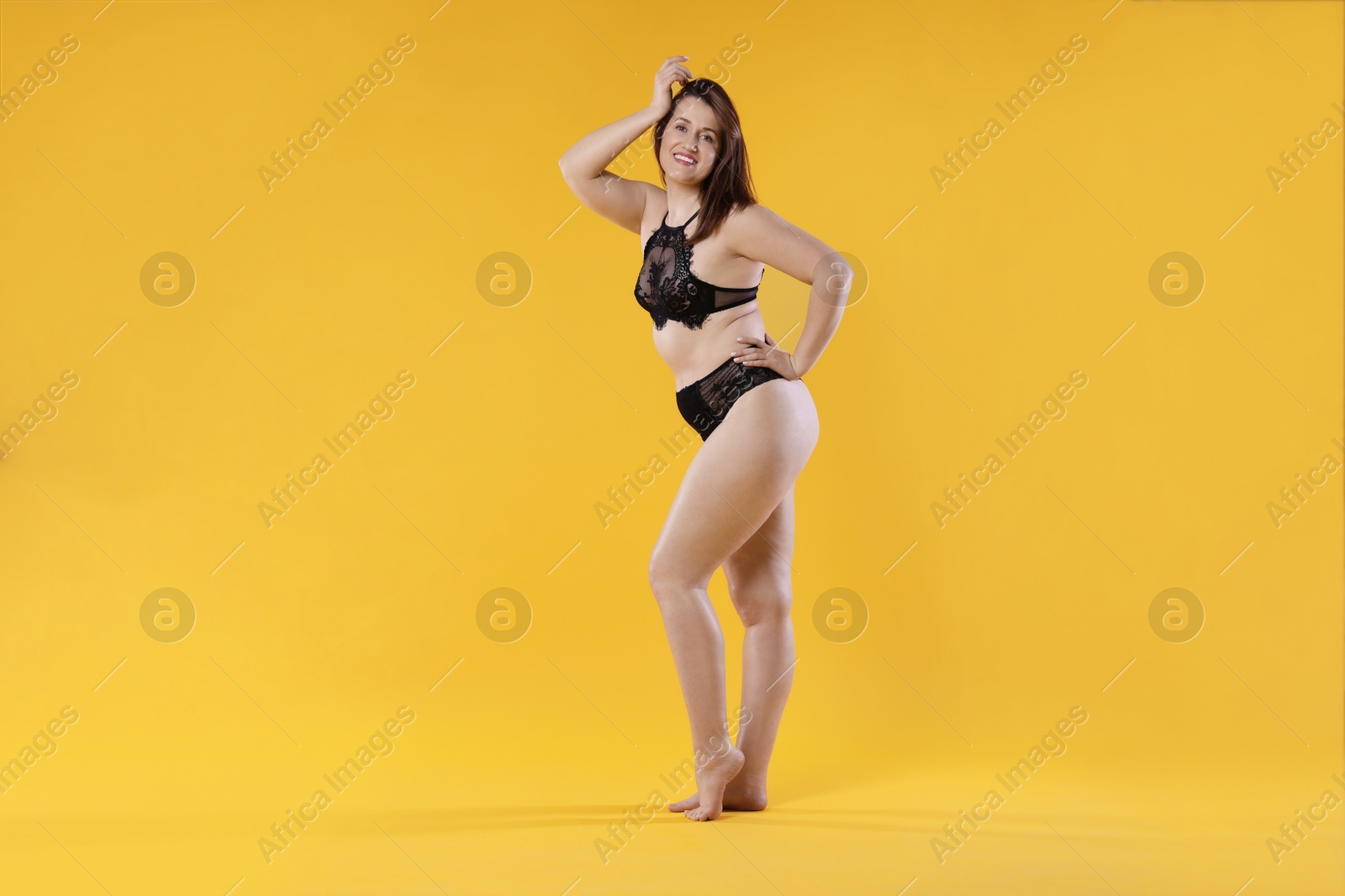 Photo of Woman in underwear on orange background. Cellulite problem