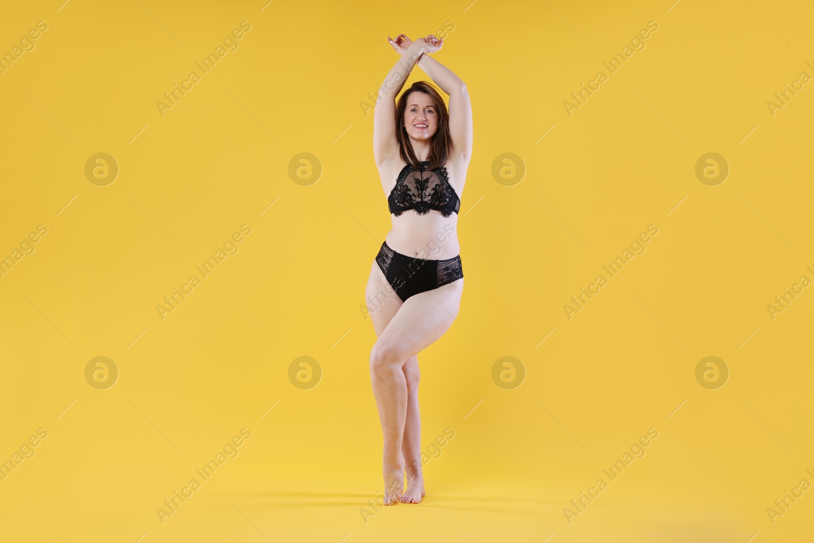 Photo of Woman in underwear on orange background. Cellulite problem