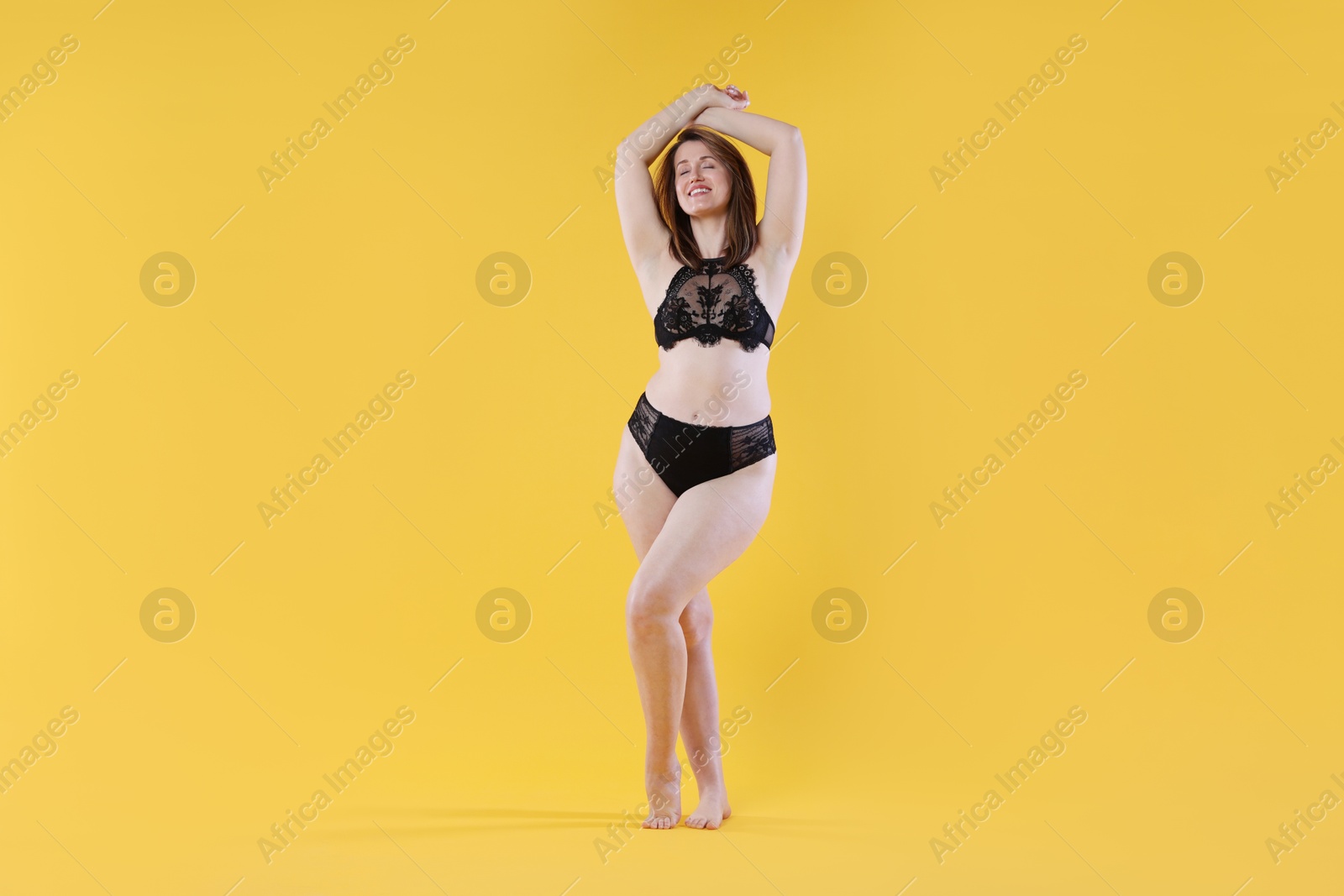 Photo of Woman in underwear on orange background. Cellulite problem