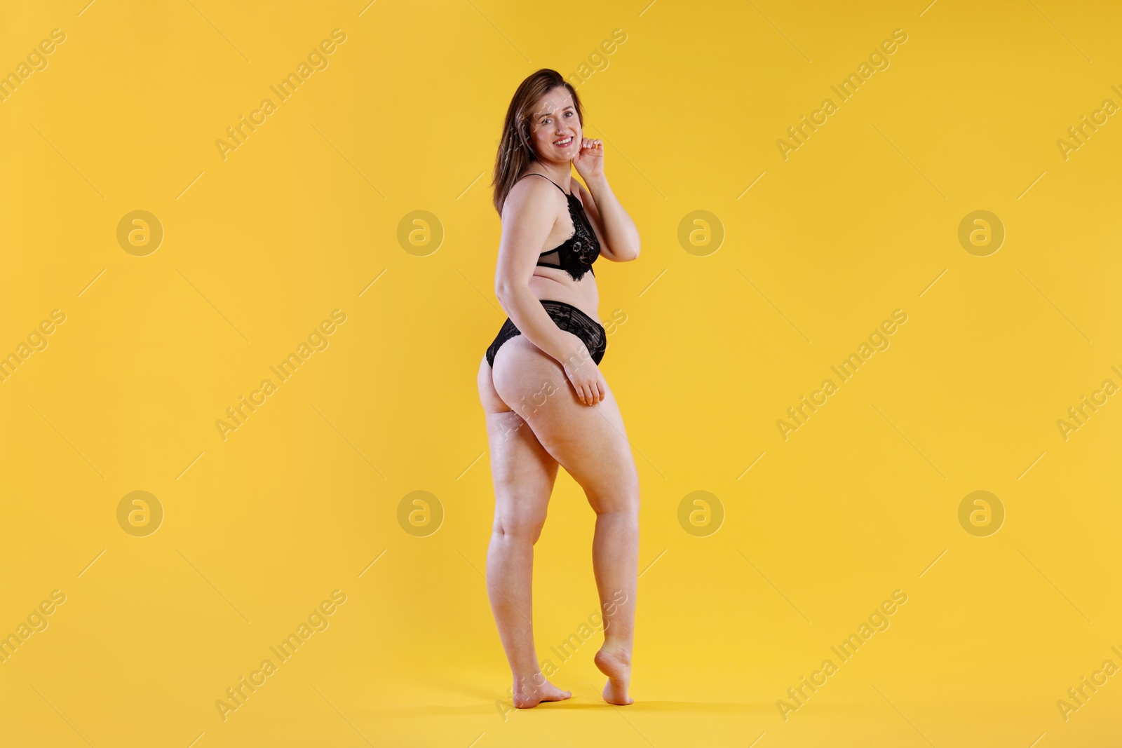 Photo of Woman in underwear on orange background. Cellulite problem