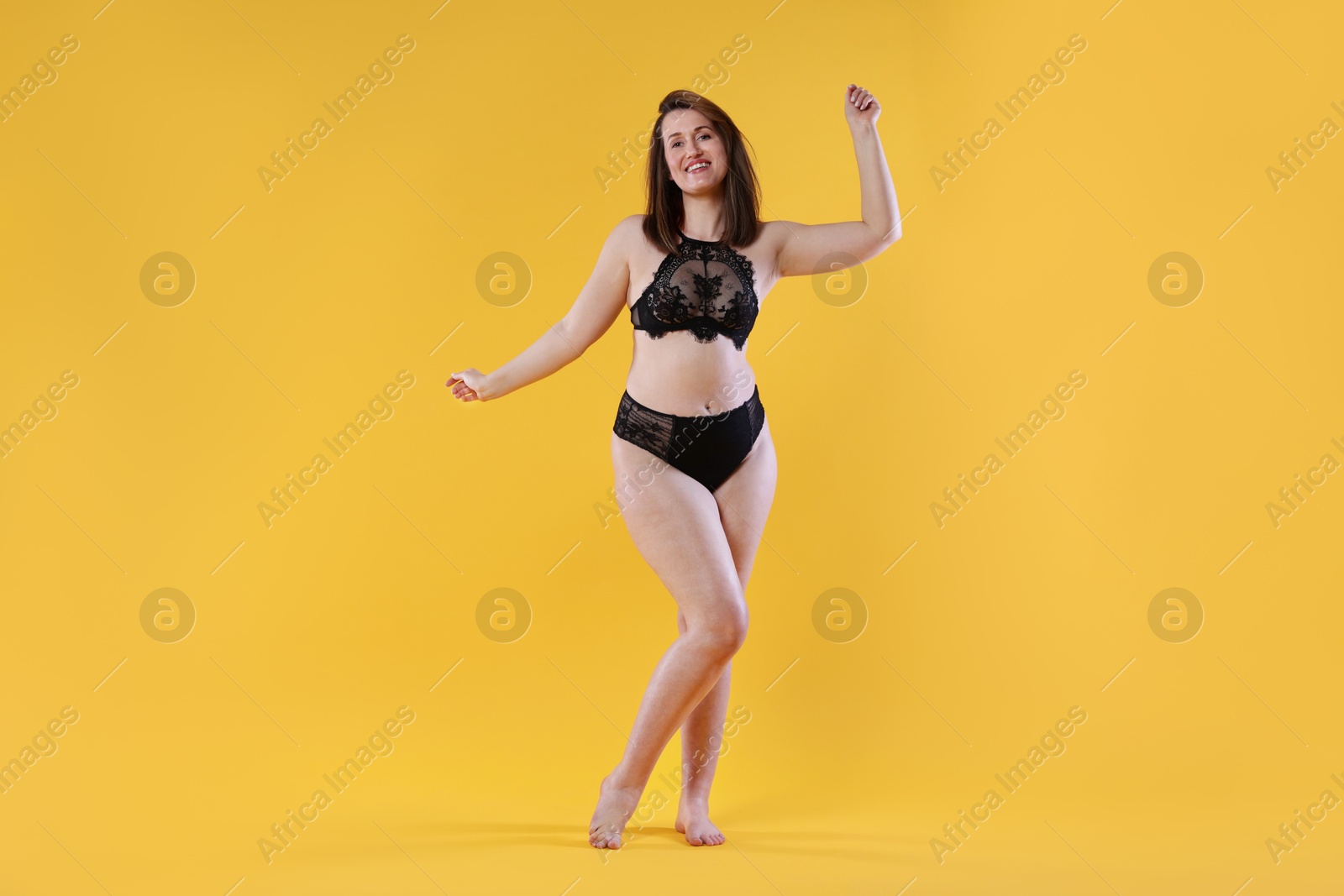 Photo of Woman in underwear on orange background. Cellulite problem