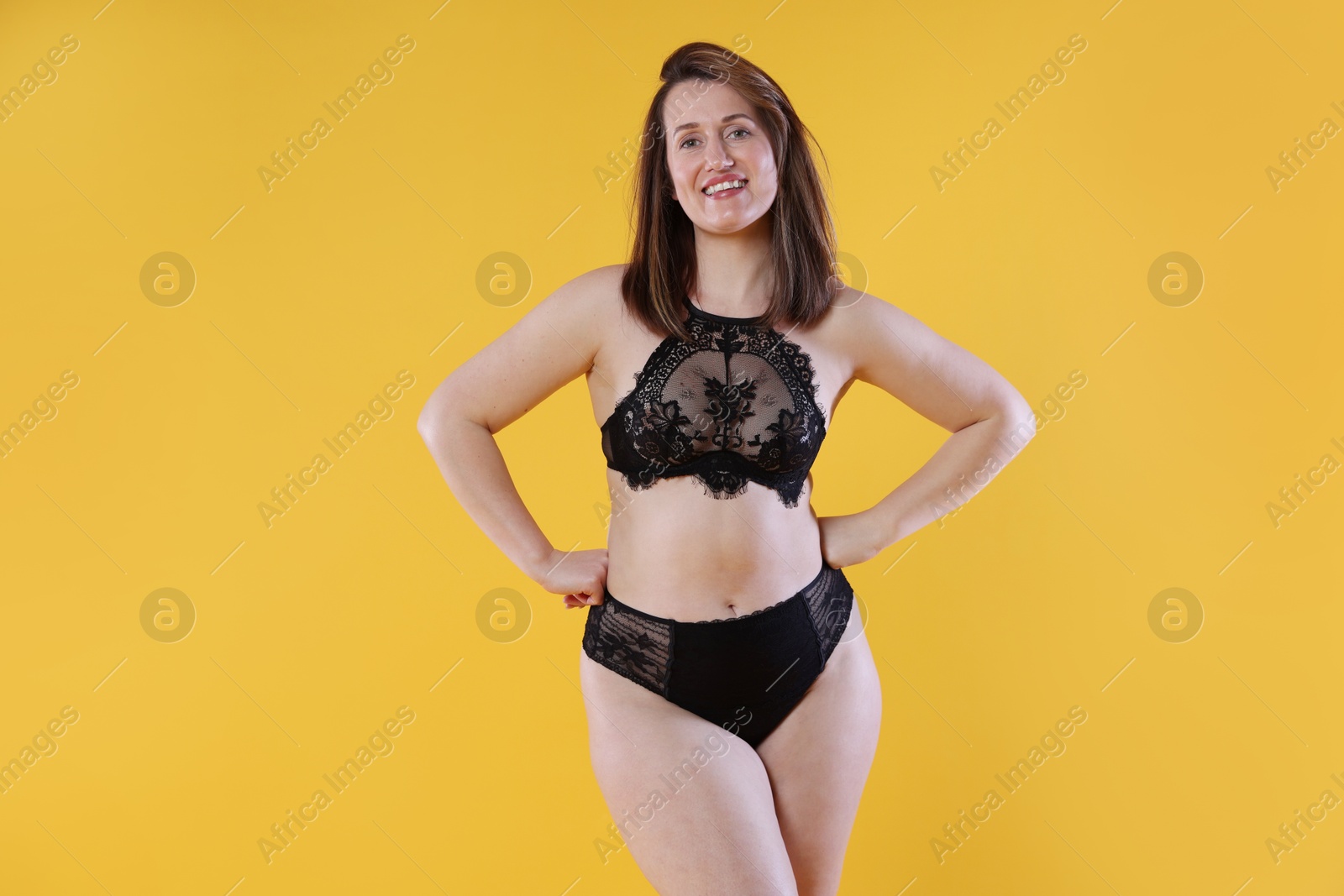 Photo of Woman in underwear on orange background. Cellulite problem