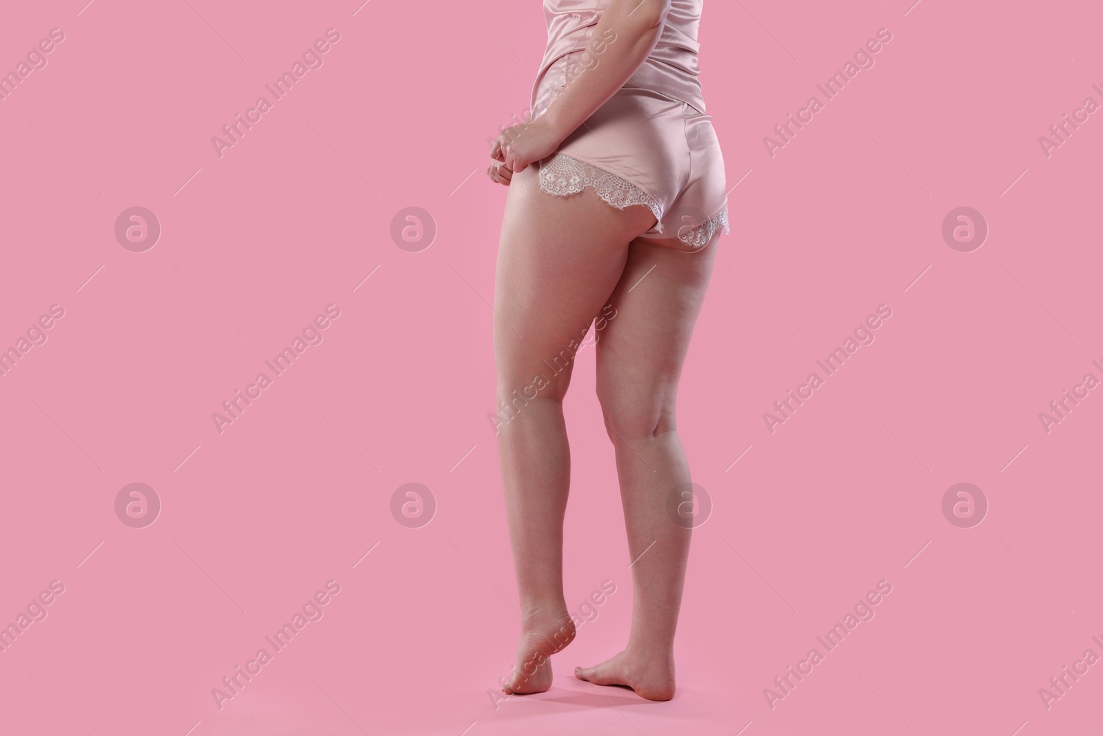 Photo of Woman in underwear on pink background, closeup. Cellulite problem