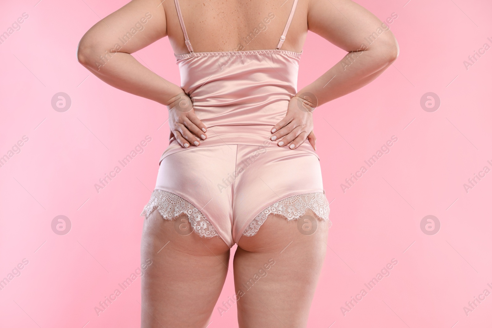 Photo of Woman in underwear on pink background, closeup. Cellulite problem