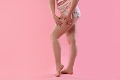 Woman with cellulite on pink background, closeup