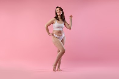 Woman in underwear on pink background. Cellulite problem