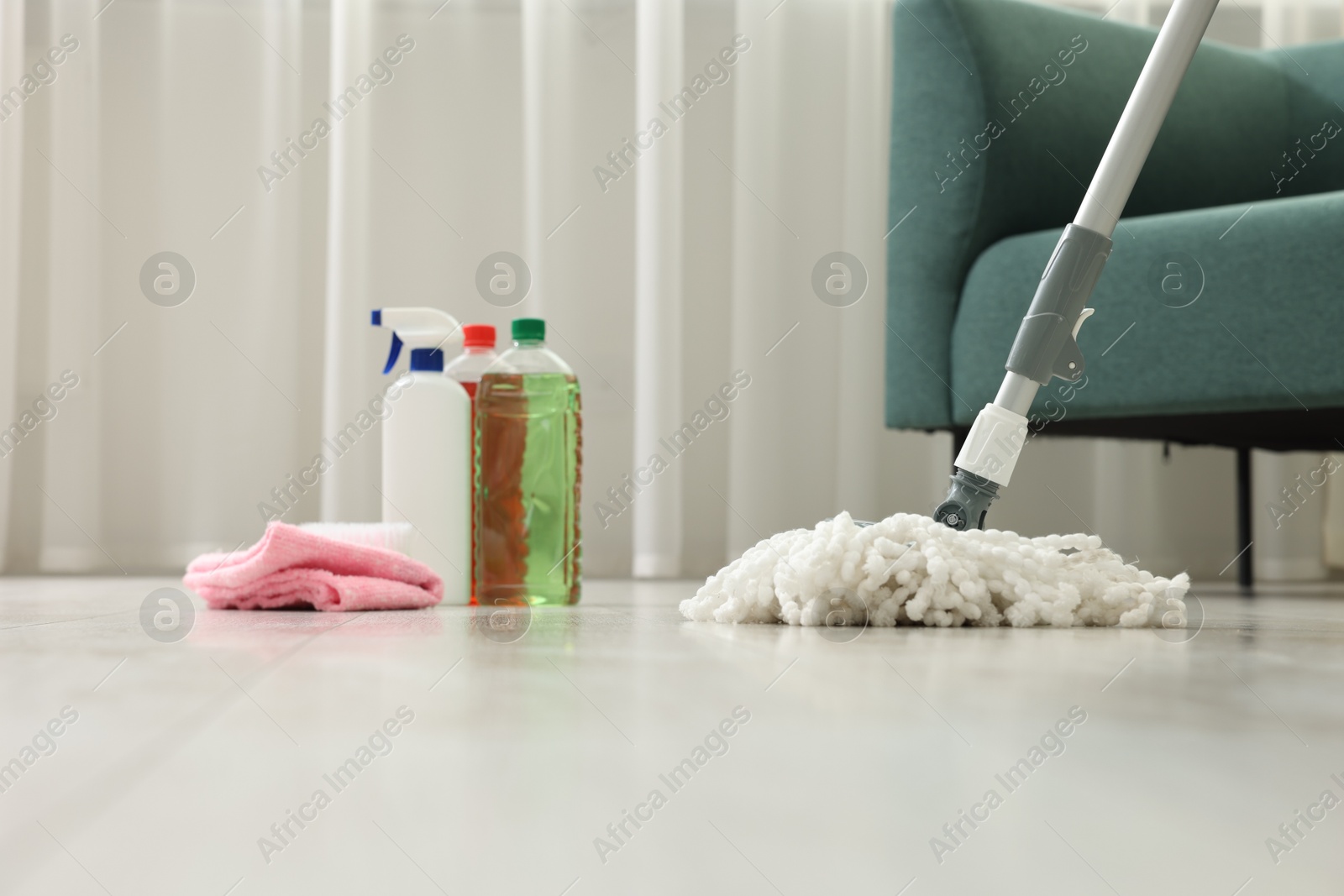 Photo of String mop, cleaning products and supplies on floor indoors