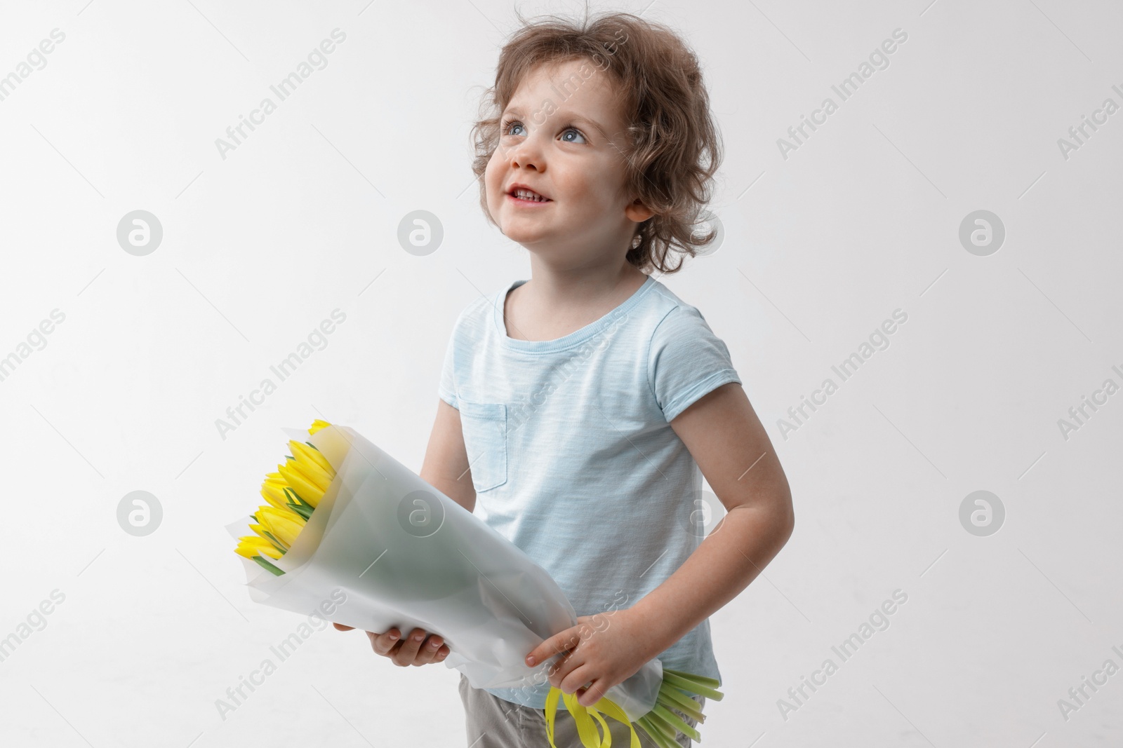 Photo of Cute little boy with bouquet of tulips on white background