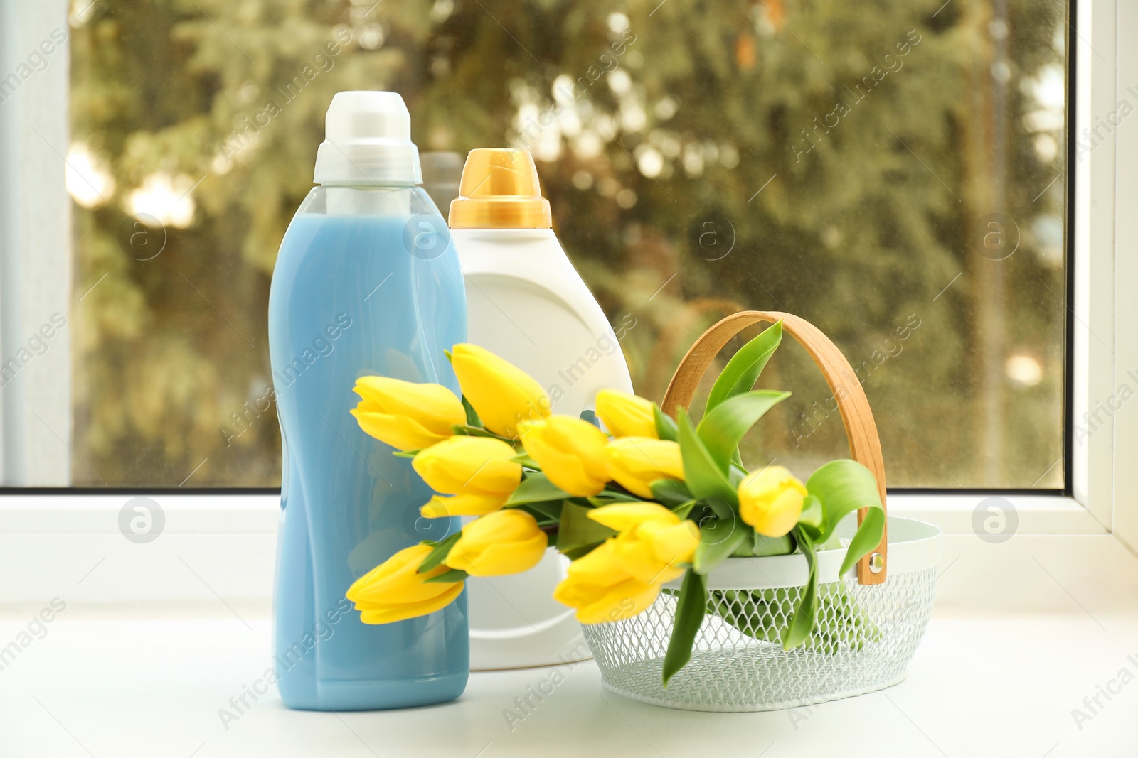 Photo of Spring cleaning. Detergents, supplies and tulips on windowsill indoors