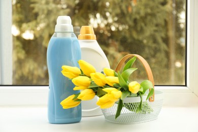 Photo of Spring cleaning. Detergents, supplies and tulips on windowsill indoors