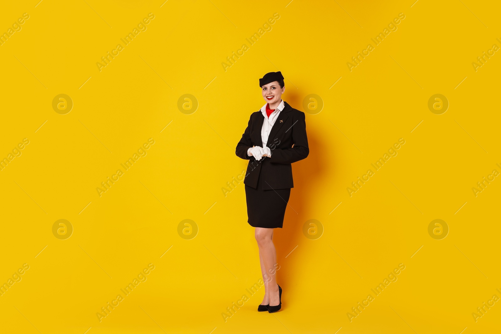 Photo of Happy flight attendant on yellow background. Space for text