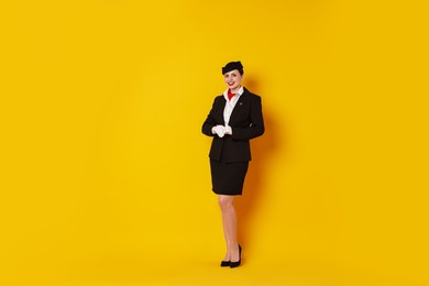 Photo of Happy flight attendant on yellow background. Space for text