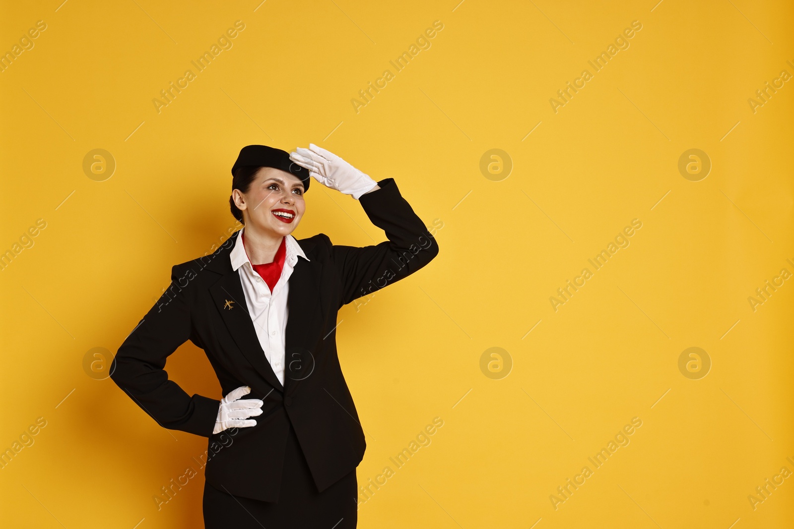 Photo of Happy flight attendant on orange background. Space for text