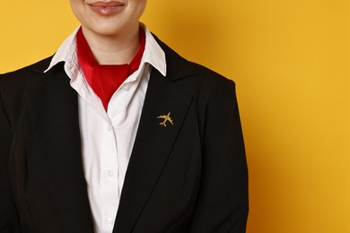 Flight attendant on orange background, closeup. Space for text