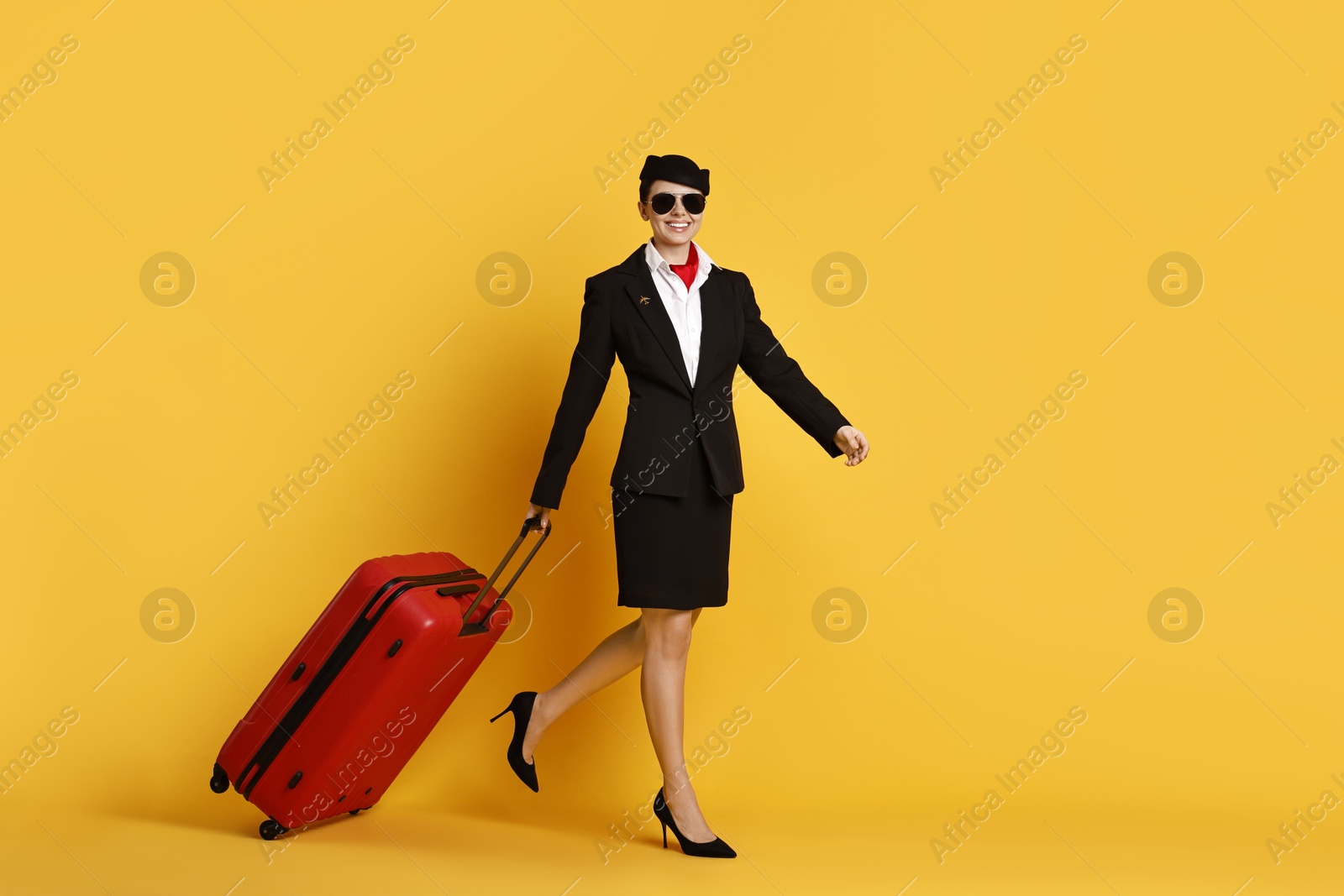 Photo of Happy flight attendant with suitcase on yellow background. Space for text