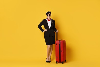 Photo of Happy flight attendant with suitcase on yellow background