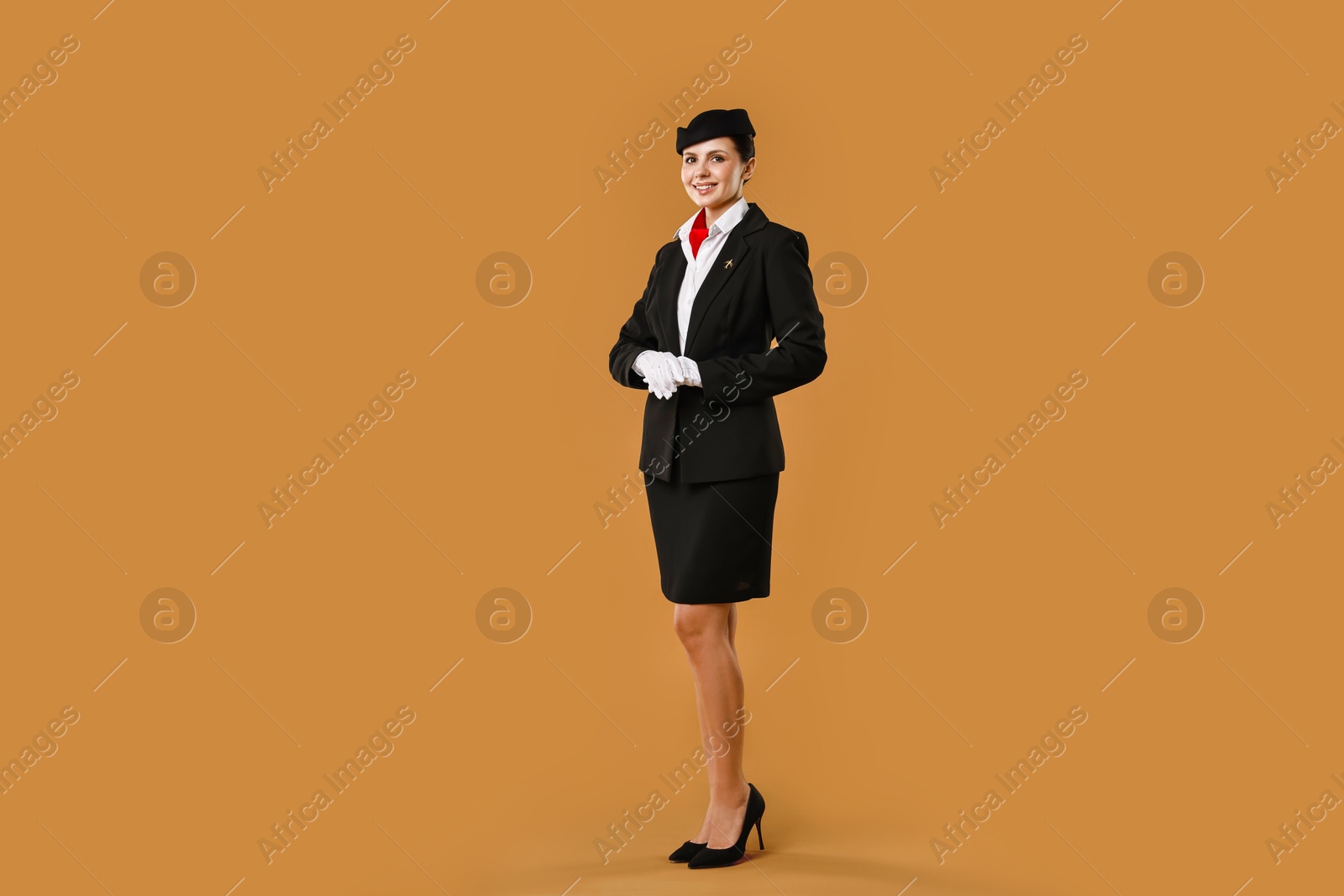 Photo of Smiling flight attendant on beige background. Space for text