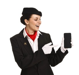 Happy flight attendant pointing at smartphone on white background