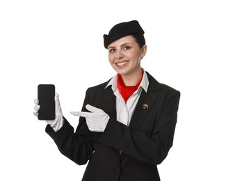 Happy flight attendant pointing at smartphone on white background