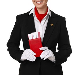 Photo of Happy stewardess holding passport with flight tickets on white background, closeup