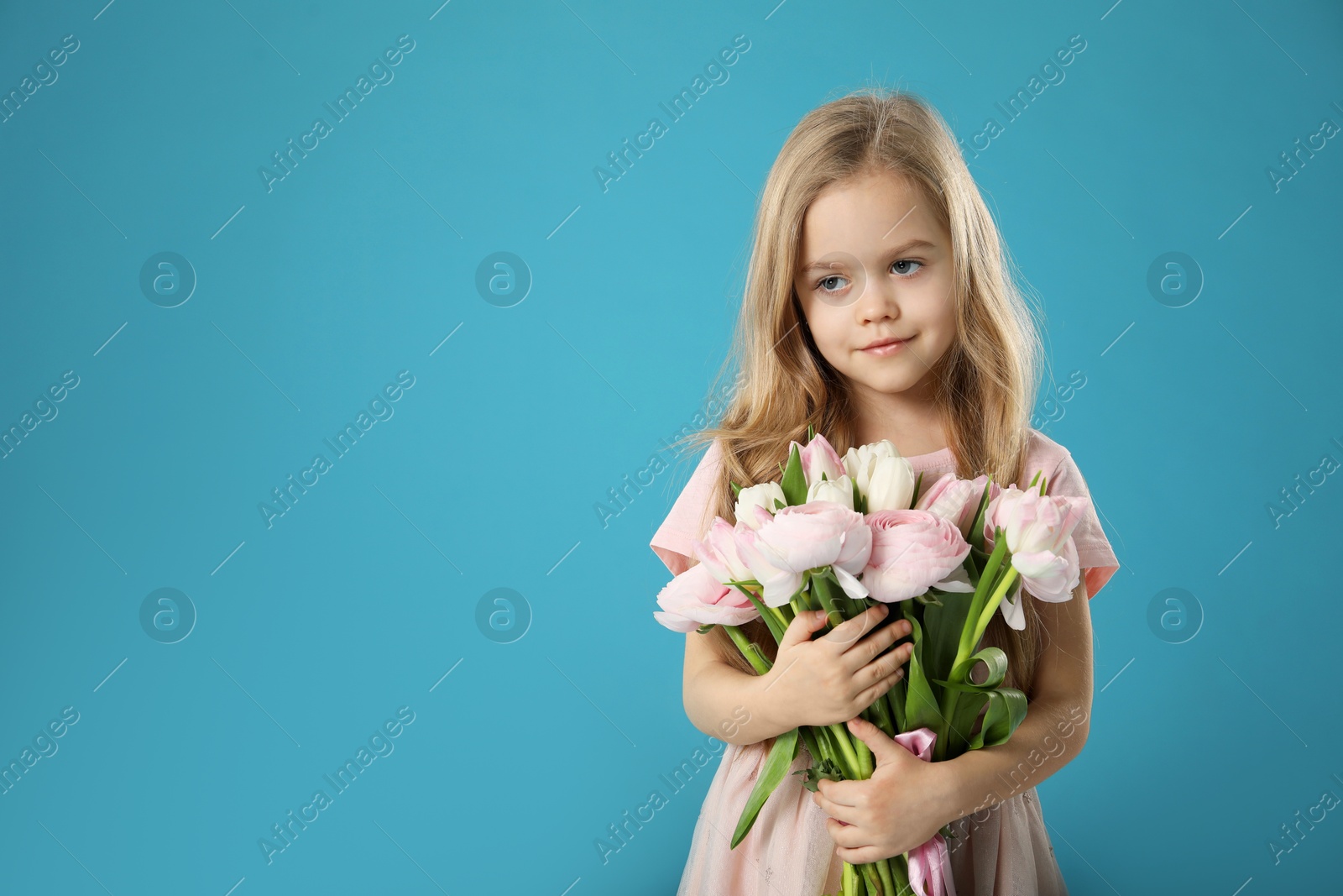 Photo of Cute little girl with bouquet of beautiful spring flowers on light blue background, space for text