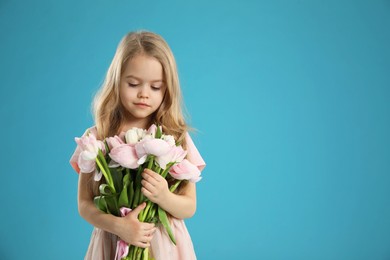 Photo of Cute little girl with bouquet of beautiful spring flowers on light blue background, space for text