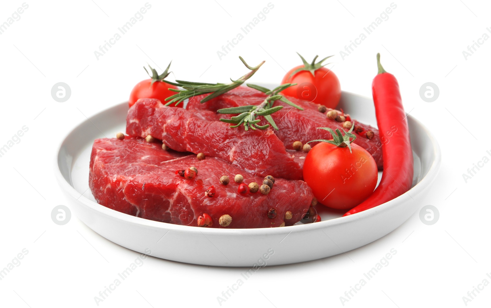 Photo of Pieces of raw beef meat, spices and tomatoes isolated on white