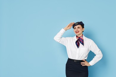 Photo of Happy flight attendant on light blue background. Space for text