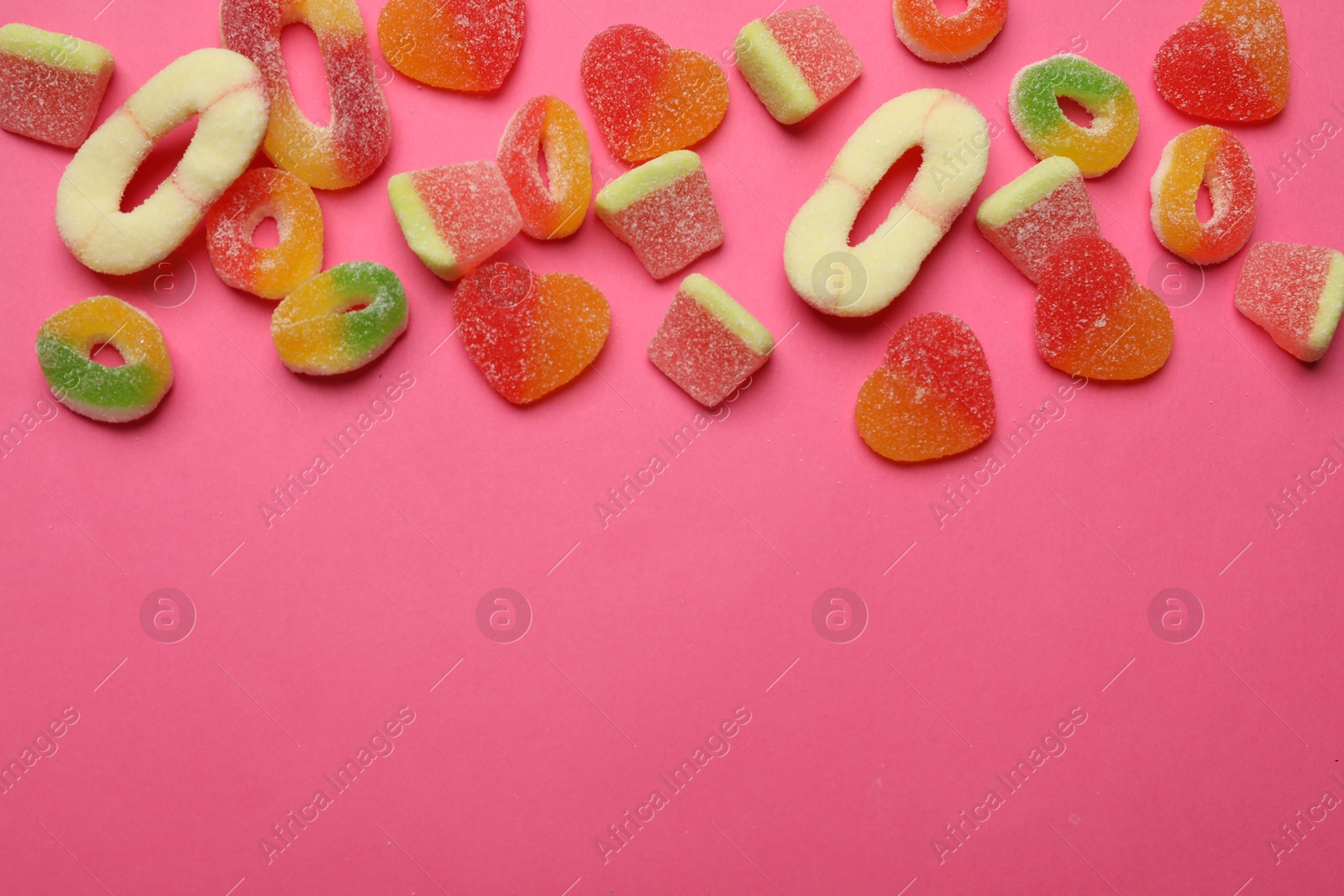 Photo of Many different tasty candies on bright pink background, flat lay. Space for text