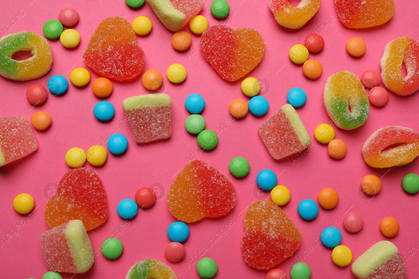 Photo of Many different tasty candies on bright pink background, flat lay